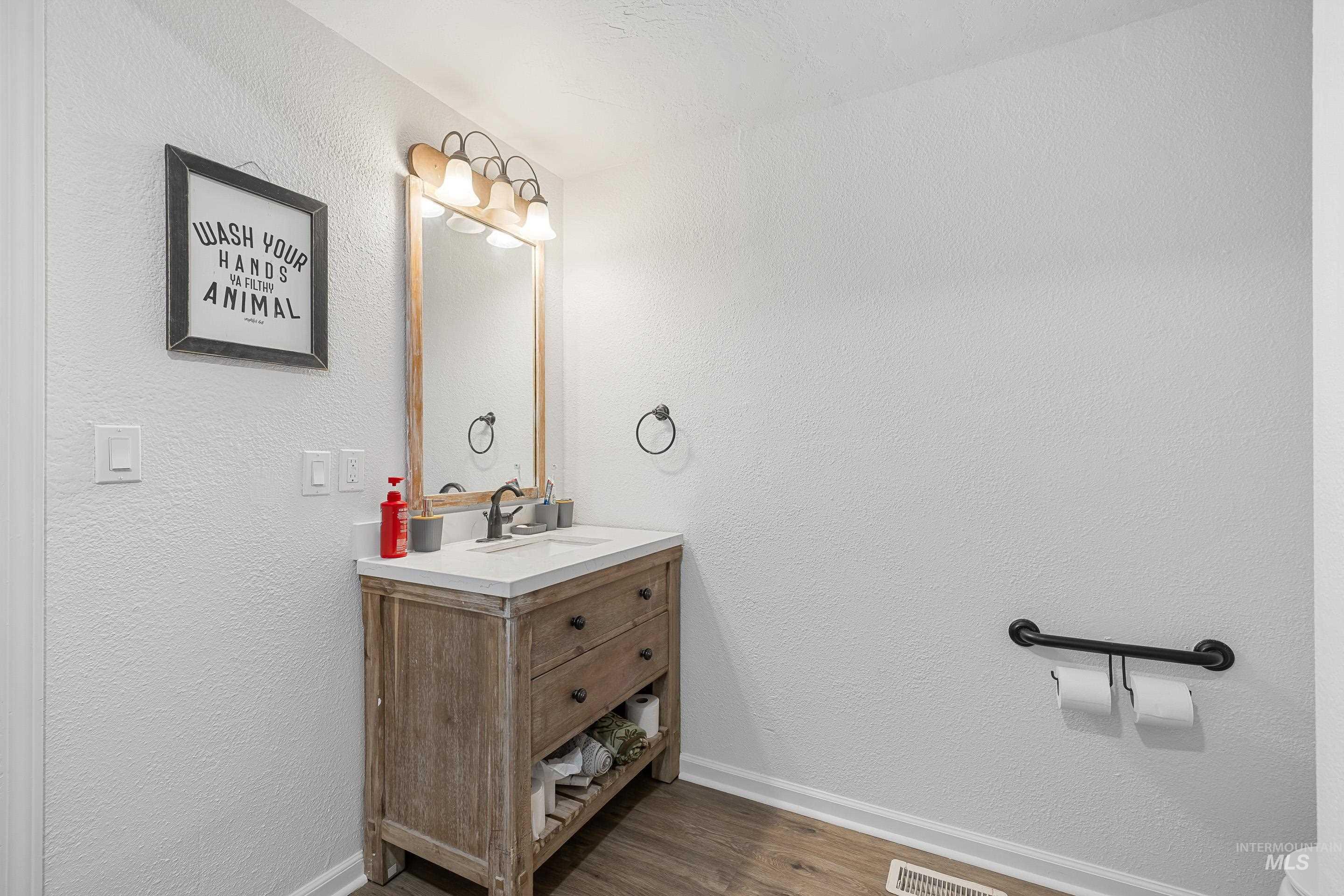 10294 West Fox Ridge Drive Boise, ID 83709 - Photo 38 of 50 Bathroom featuring vanity, a textured wall, and dark wood-style flooring