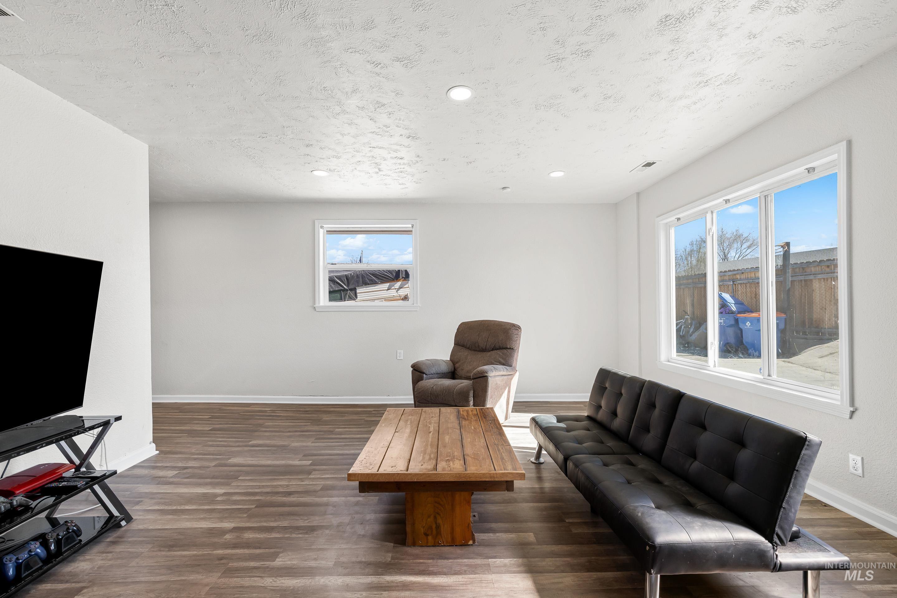 10294 West Fox Ridge Drive Boise, ID 83709 - Photo 6 of 50 Living area with dark wood-style flooring, a textured ceiling, and recessed lighting