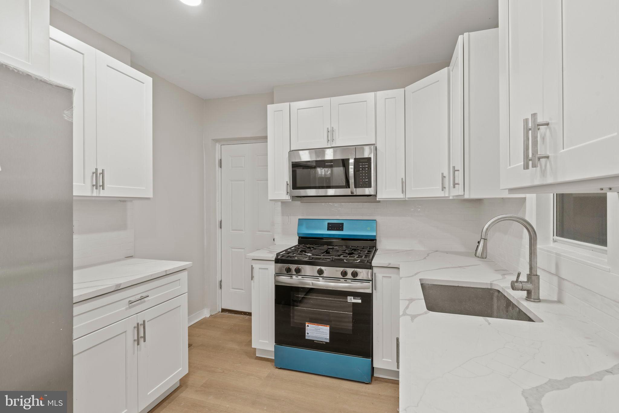 2321 West Firth Street Philadelphia, PA 19132 - Photo 15 of 21 Modern kitchen with sleek white cabinetry.