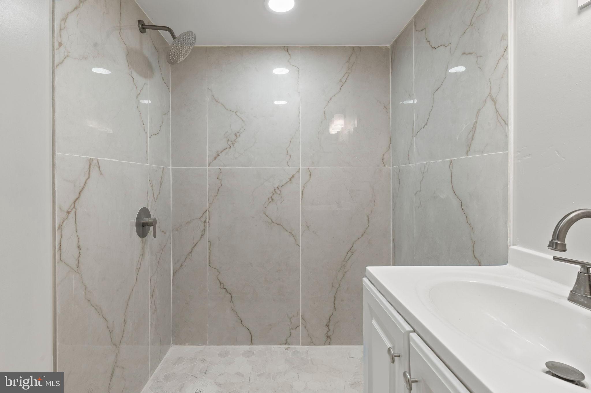 2321 West Firth Street Philadelphia, PA 19132 - Photo 17 of 21 Sleek modern shower with elegant marble tiles.