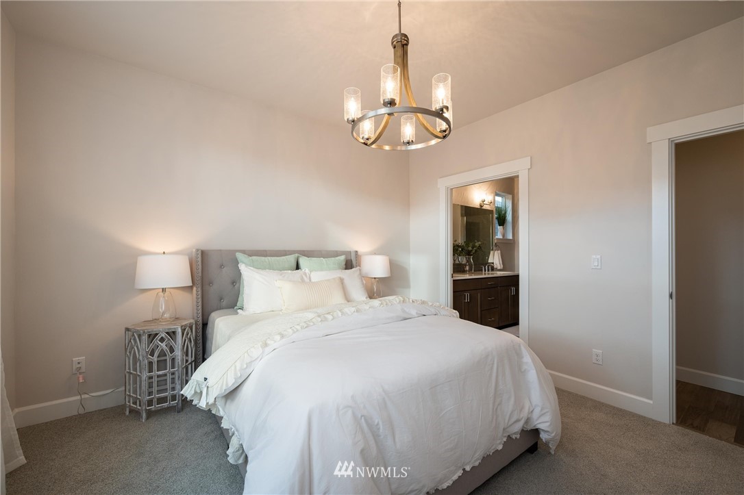 1411 Woods Point Loop Ferndale, WA 98248 - Photo 15 of 31 a bedroom with a bed and a chandelier