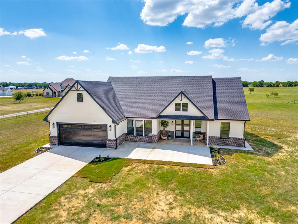 3150 Crisp Road Ennis, TX 75119 - Photo 1 of 30 Modern farmhouse-style residence featuring a dark shingle roof, white siding, and dark brick accents