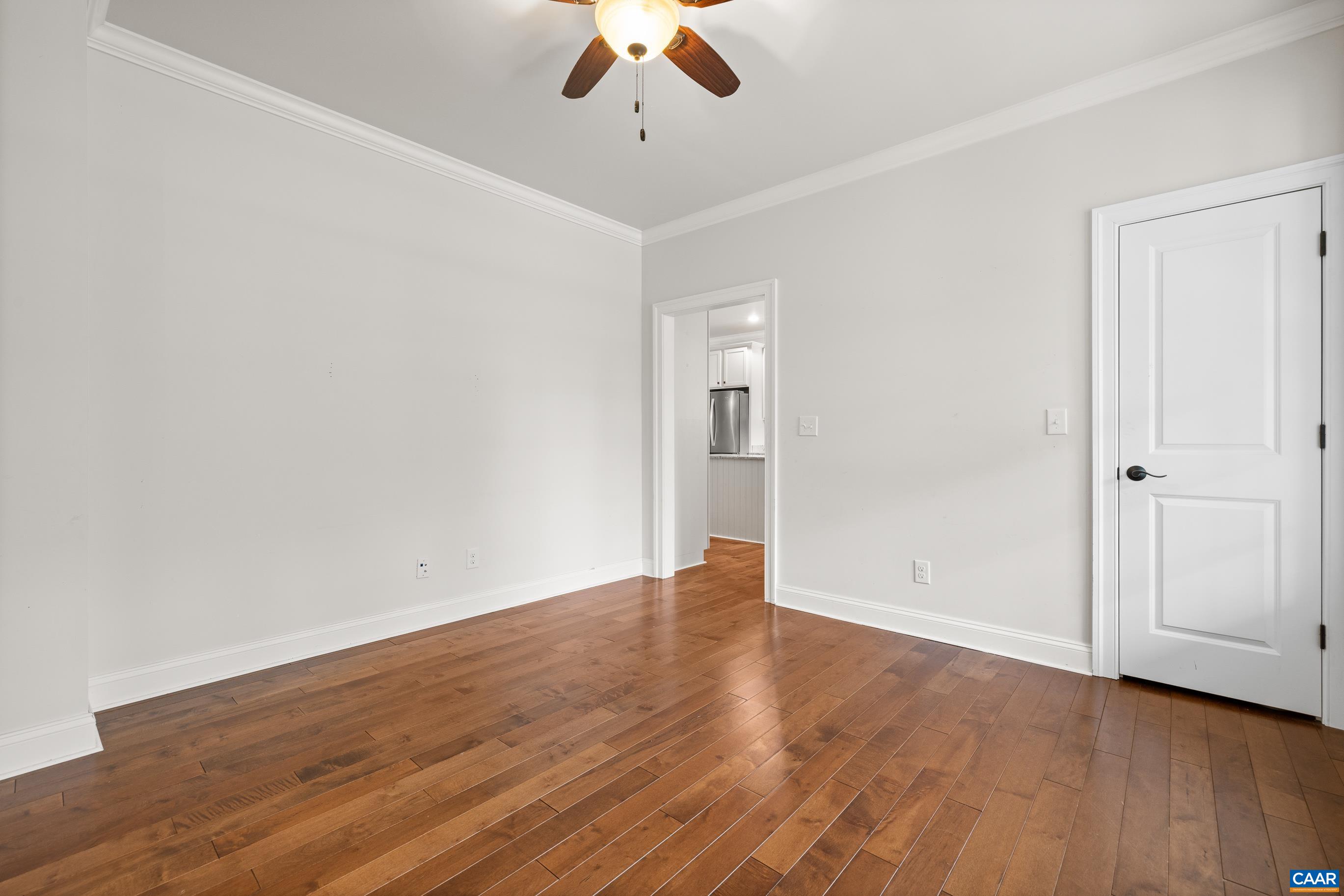 7325 3 Notch Road Louisa, VA 23093 - Photo 16 of 65 an empty room with wooden floor chandelier fan and windows