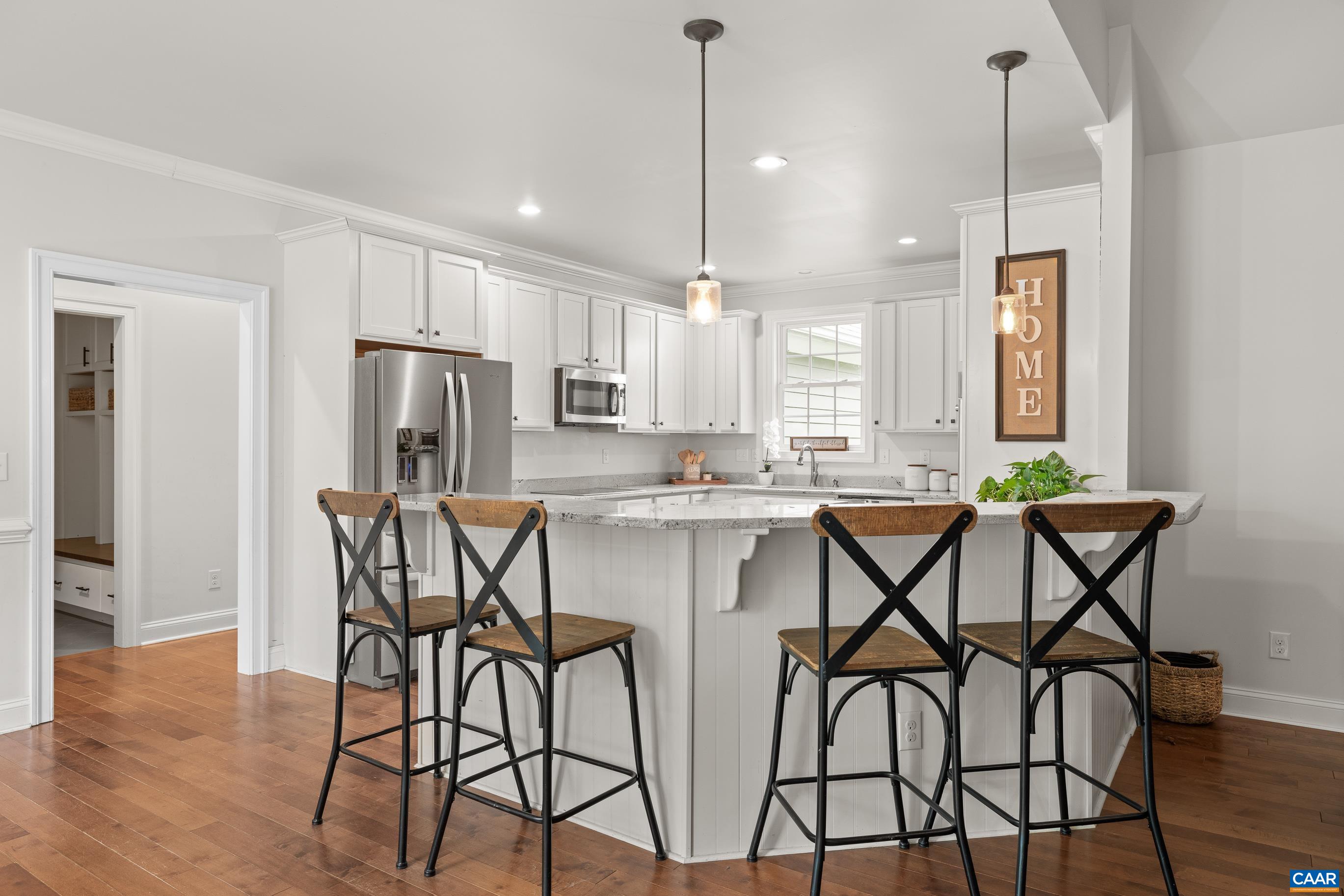 7325 3 Notch Road Louisa, VA 23093 - Photo 20 of 65 a kitchen with stainless steel appliances a dining table chairs refrigerator and microwave