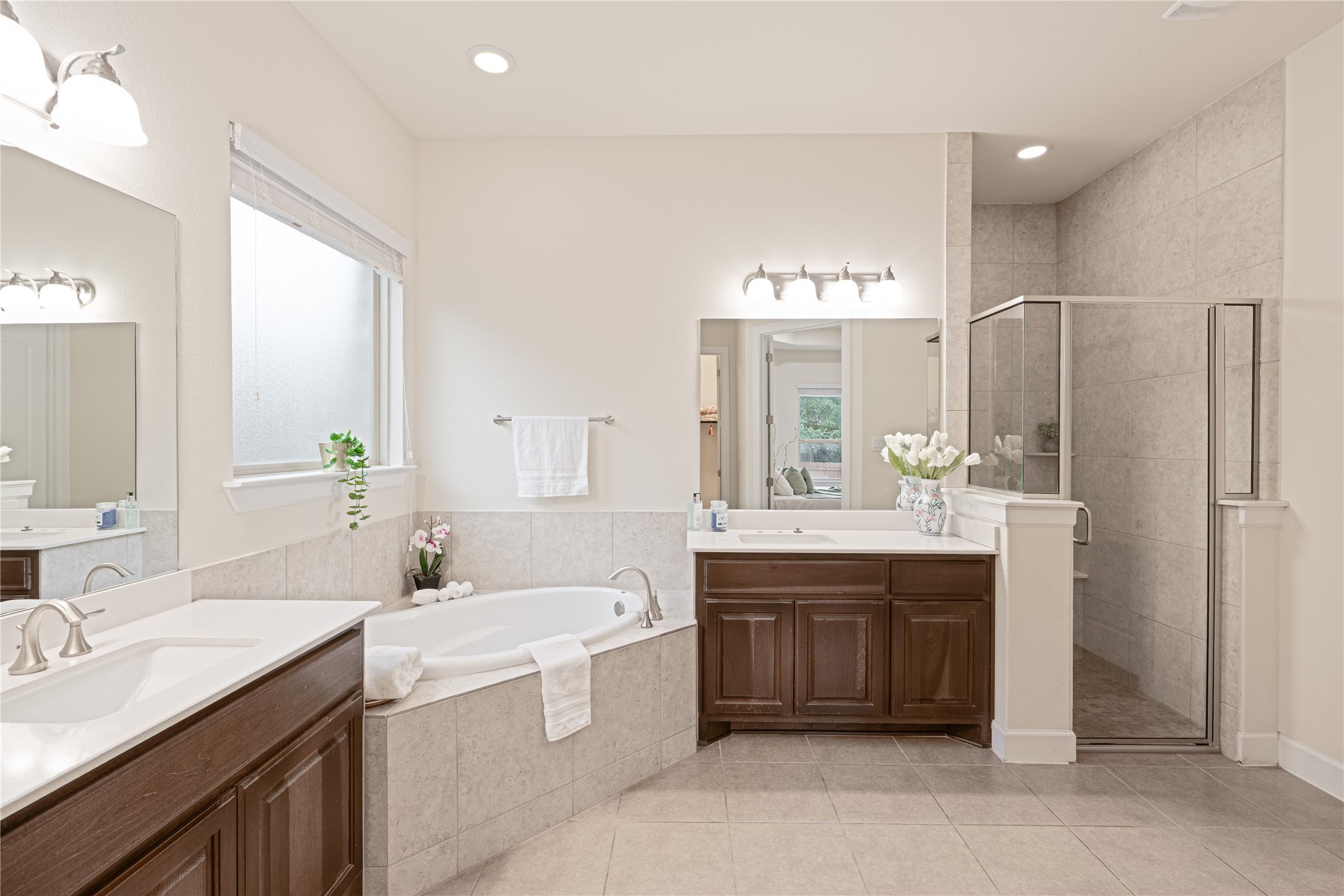 228 Lockhart Loop Georgetown, TX 78628 - Photo 17 of 37 Full bathroom featuring tile patterned flooring, two vanities, a shower stall, a bath, and recessed lighting