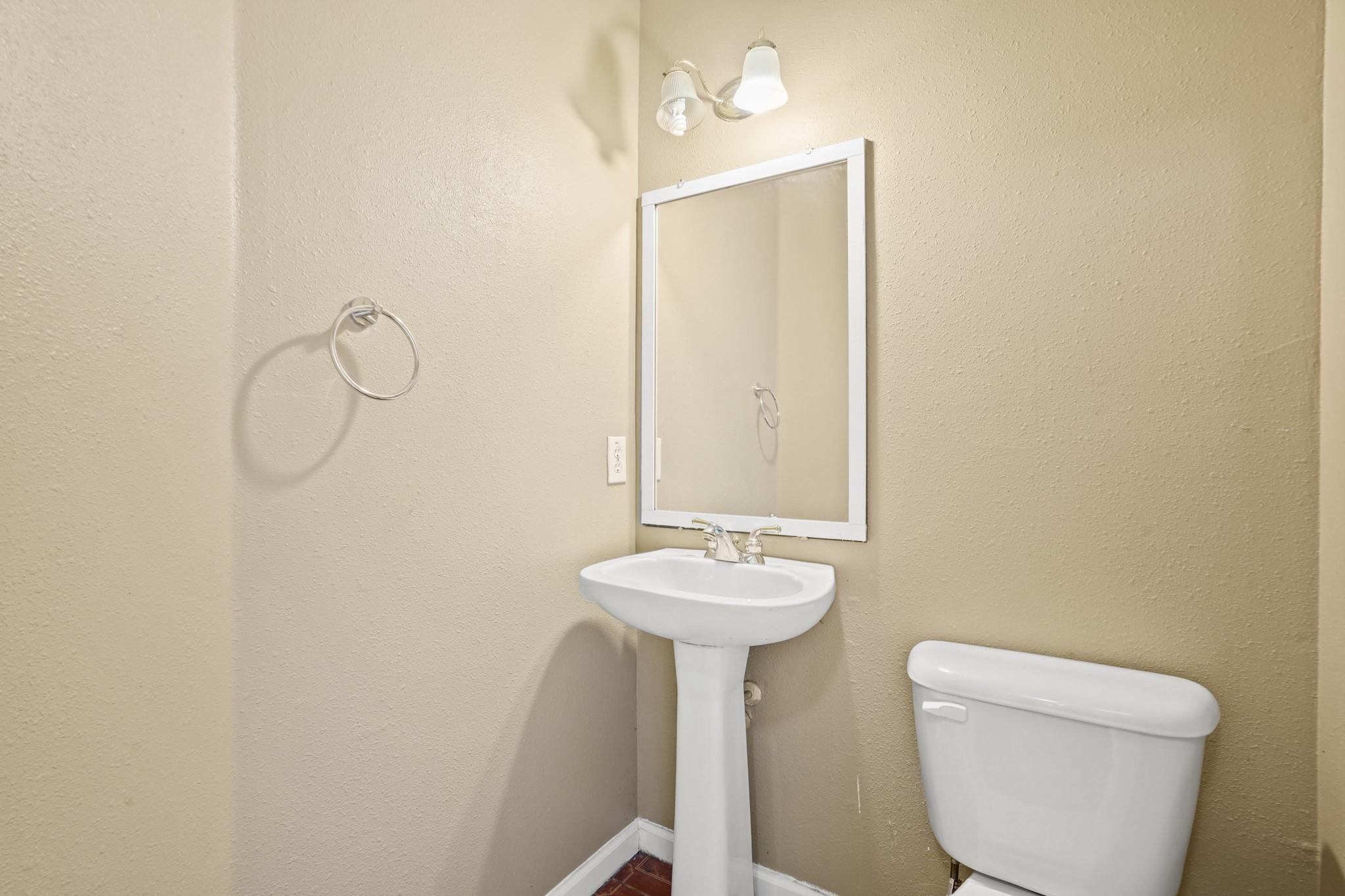 5003 East Parma Drive Rosenberg, TX 77471 - Photo 12 of 25 a bathroom with a toilet sink and mirror