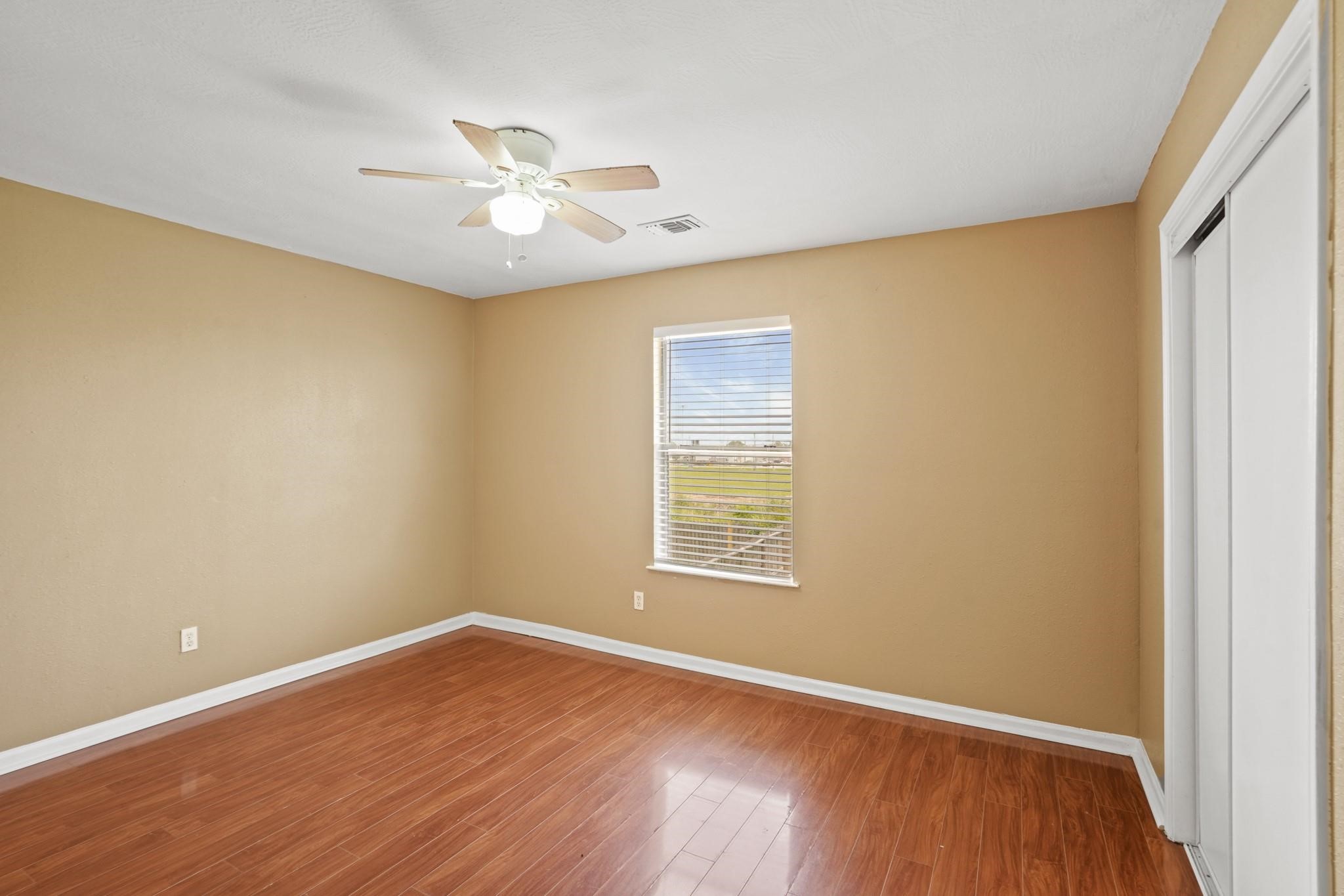 5003 East Parma Drive Rosenberg, TX 77471 - Photo 15 of 25 a view of an empty room with wooden floor and a window