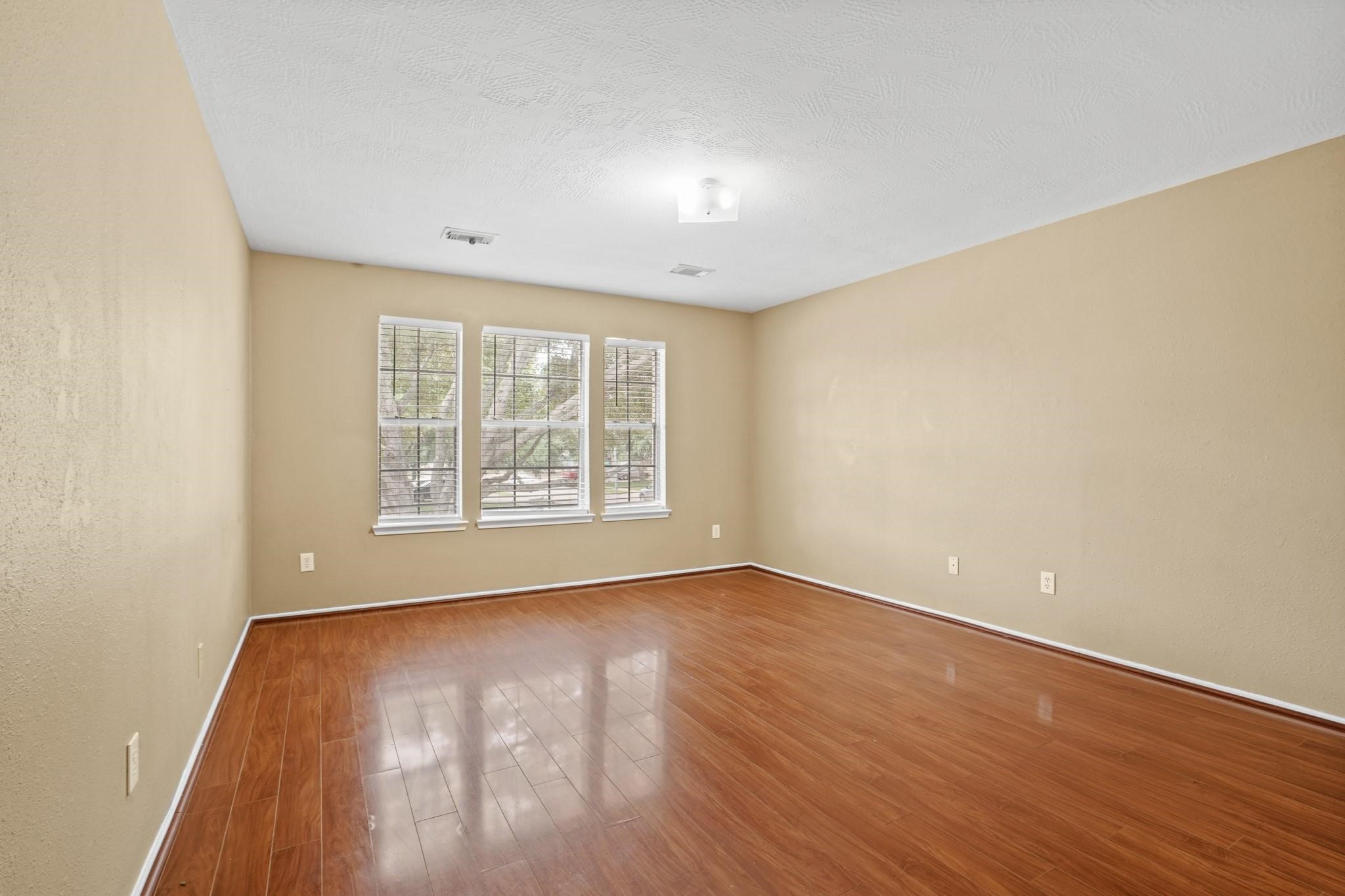 5003 East Parma Drive Rosenberg, TX 77471 - Photo 18 of 25 a view of an empty room with wooden floor and a window