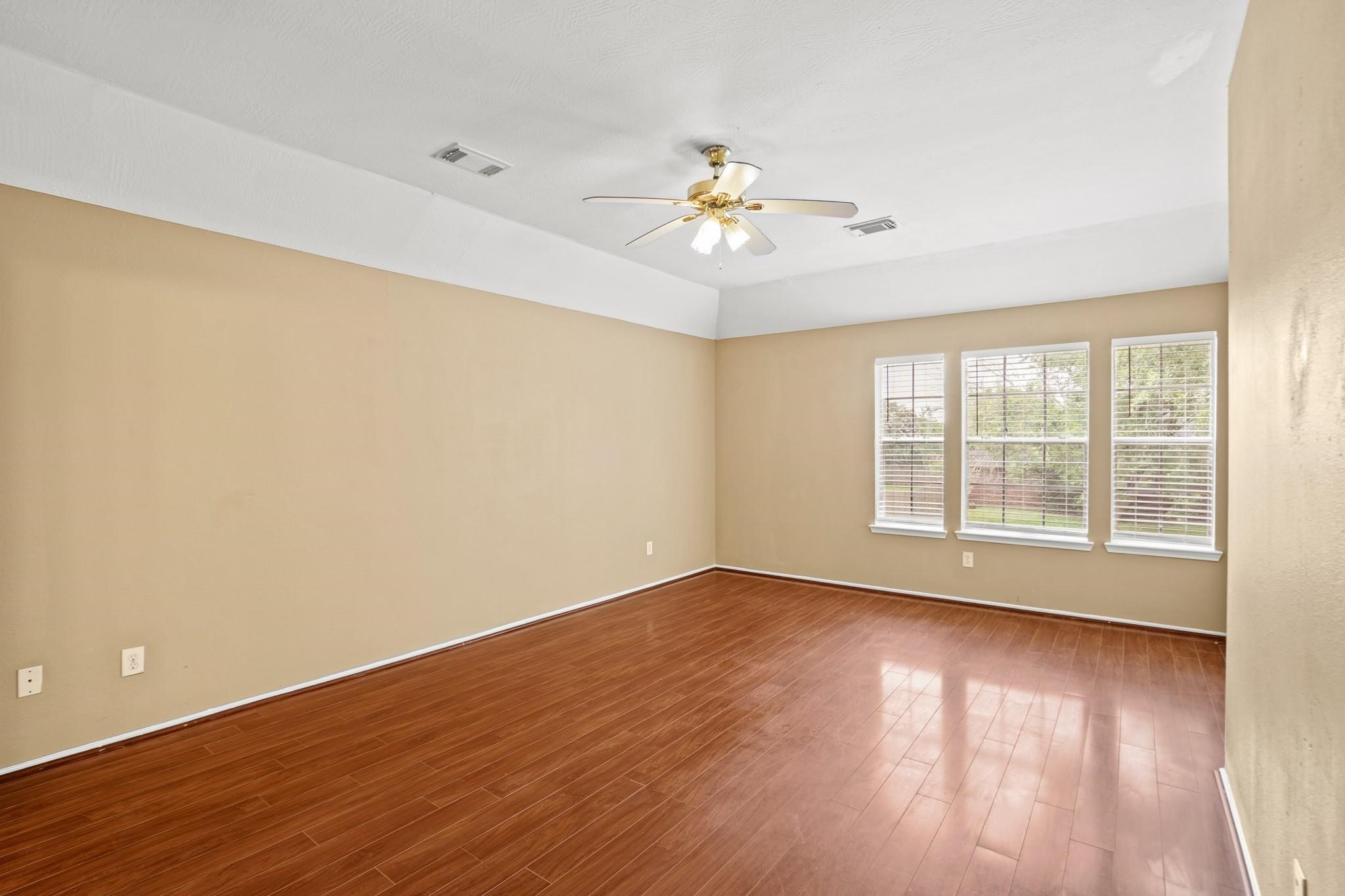 5003 East Parma Drive Rosenberg, TX 77471 - Photo 21 of 25 a view of an empty room with wooden floor and a window