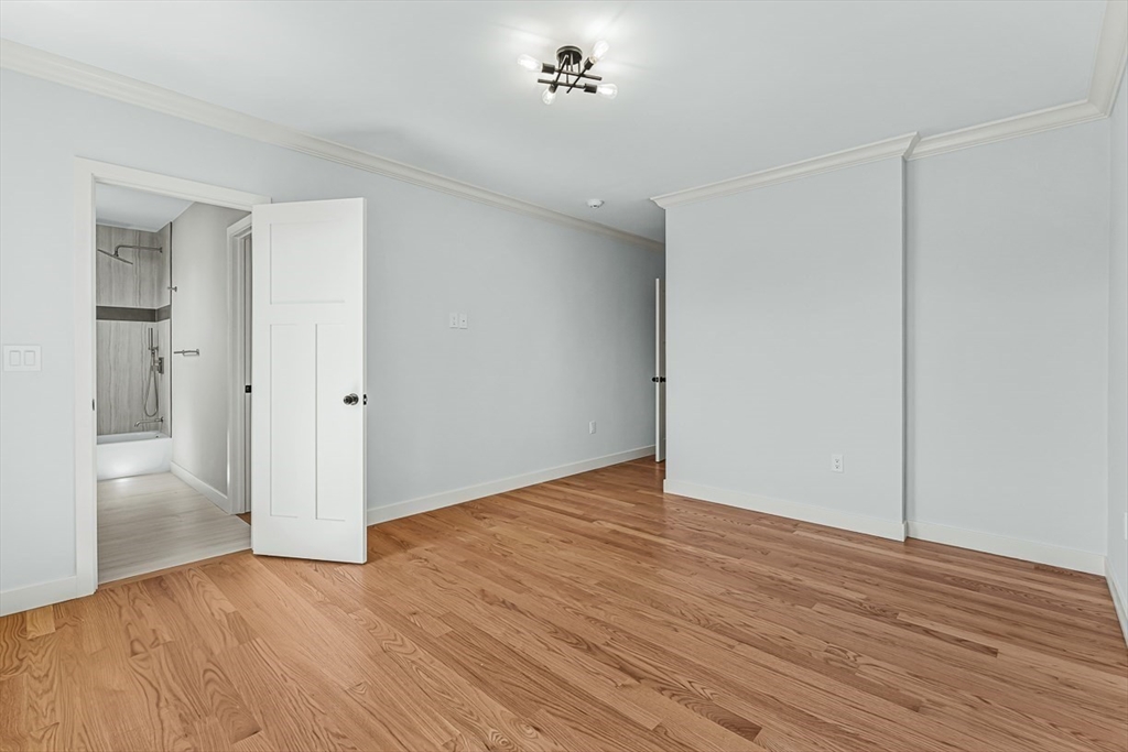 443 Central Avenue Needham, MA 02494 - Photo 29 of 41 an empty room with wooden floor and a bathroom