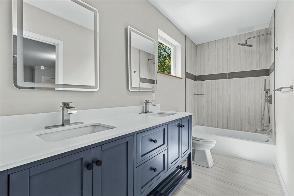 443 Central Avenue Needham, MA 02494 - Photo 31 of 41 a bathroom with a double vanity sink a toilet and a mirror