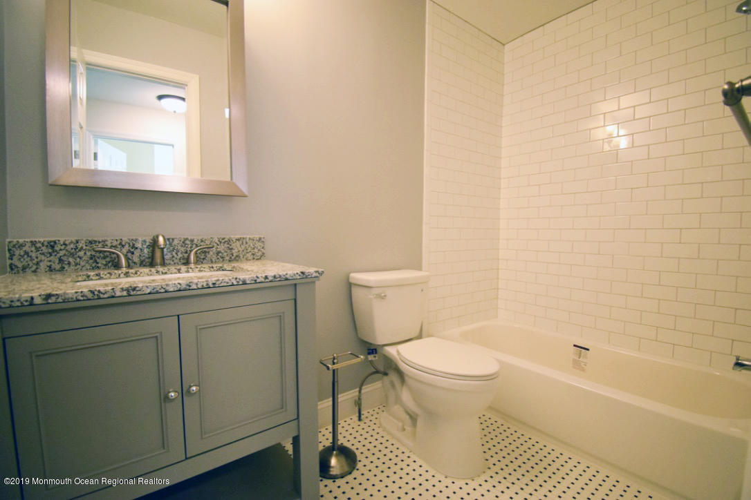 66 Starlight Road Howell, NJ 07731 - Photo 22 of 27 a bathroom with a granite countertop toilet a sink and a bathtub