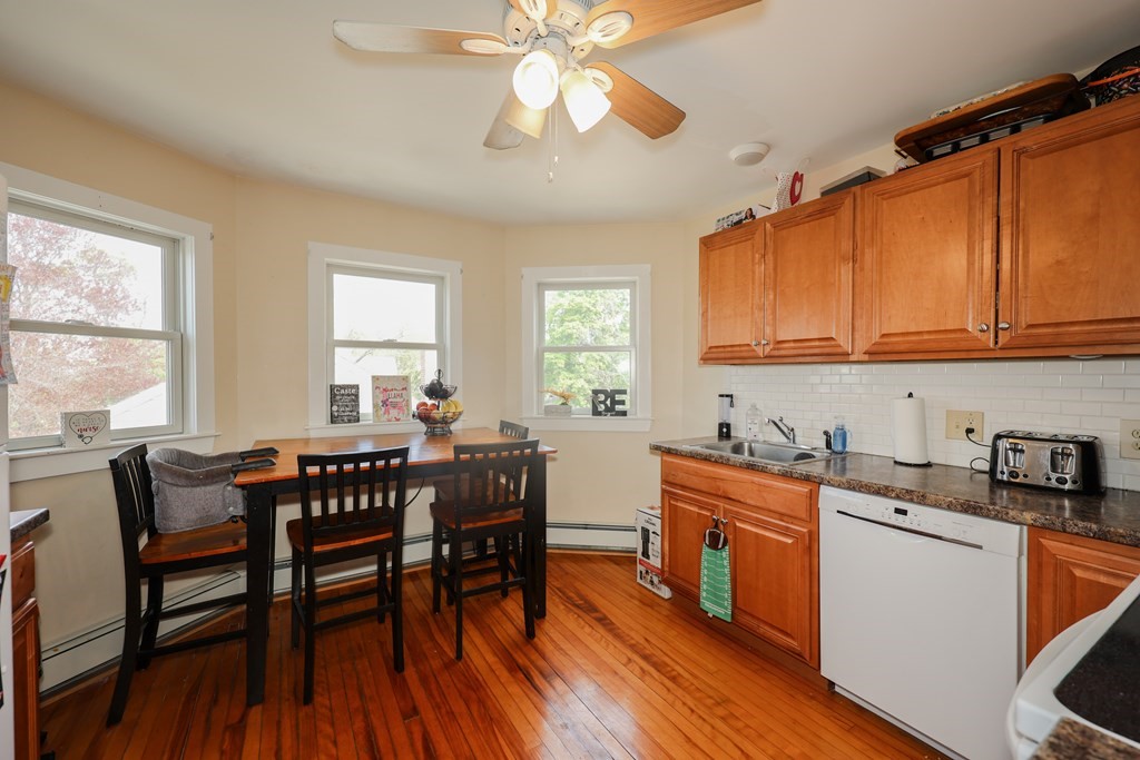 1450 Main Street Athol, MA 01331 - Photo 23 of 42 a kitchen with stainless steel appliances granite countertop a stove a sink dishwasher a dining table and chairs with wooden floor