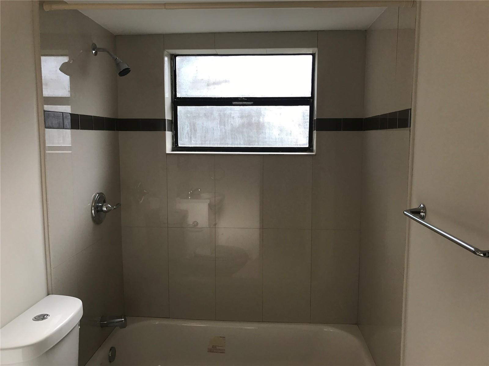 10053 Winding Lake Road, Unit 104 Sunrise, FL 33351 - Photo 14 of 44 a bathroom with a window sink and toilet