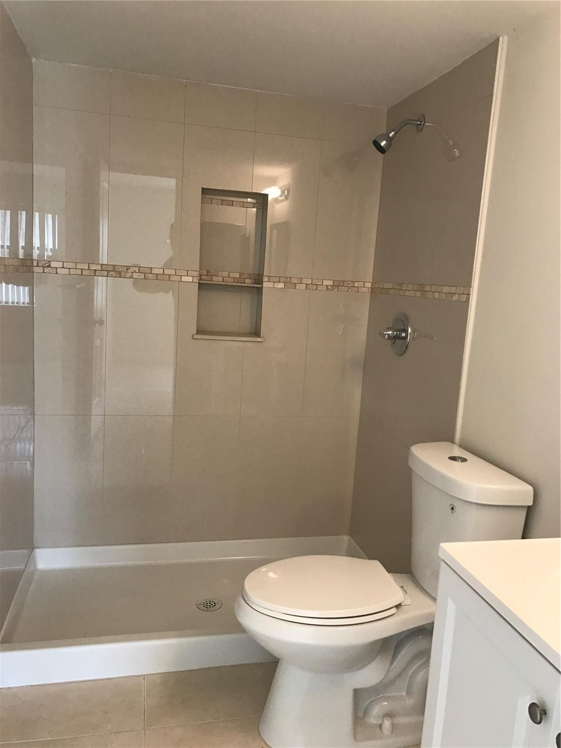 10053 Winding Lake Road, Unit 104 Sunrise, FL 33351 - Photo 21 of 44 a white toilet sitting next to a bath tub
