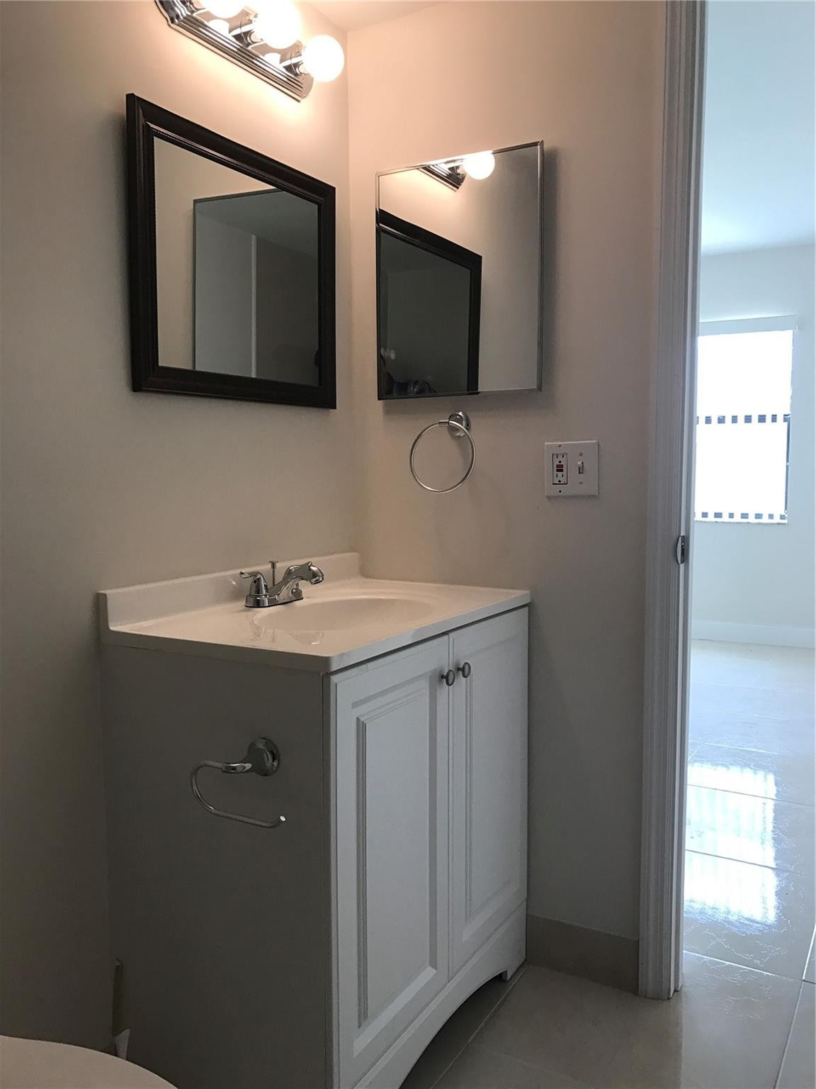 10053 Winding Lake Road, Unit 104 Sunrise, FL 33351 - Photo 22 of 44 a bathroom with 2 sink and a mirror