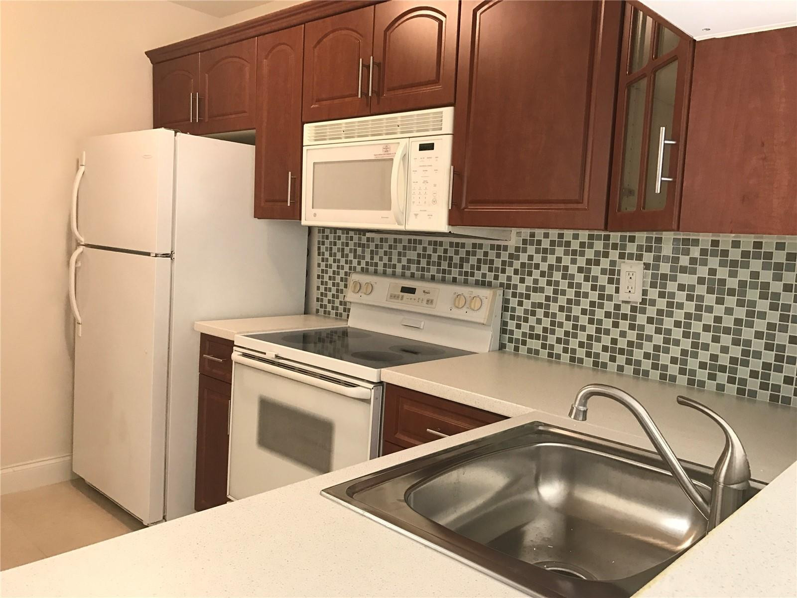 10053 Winding Lake Road, Unit 104 Sunrise, FL 33351 - Photo 3 of 44 a kitchen with a refrigerator and a sink