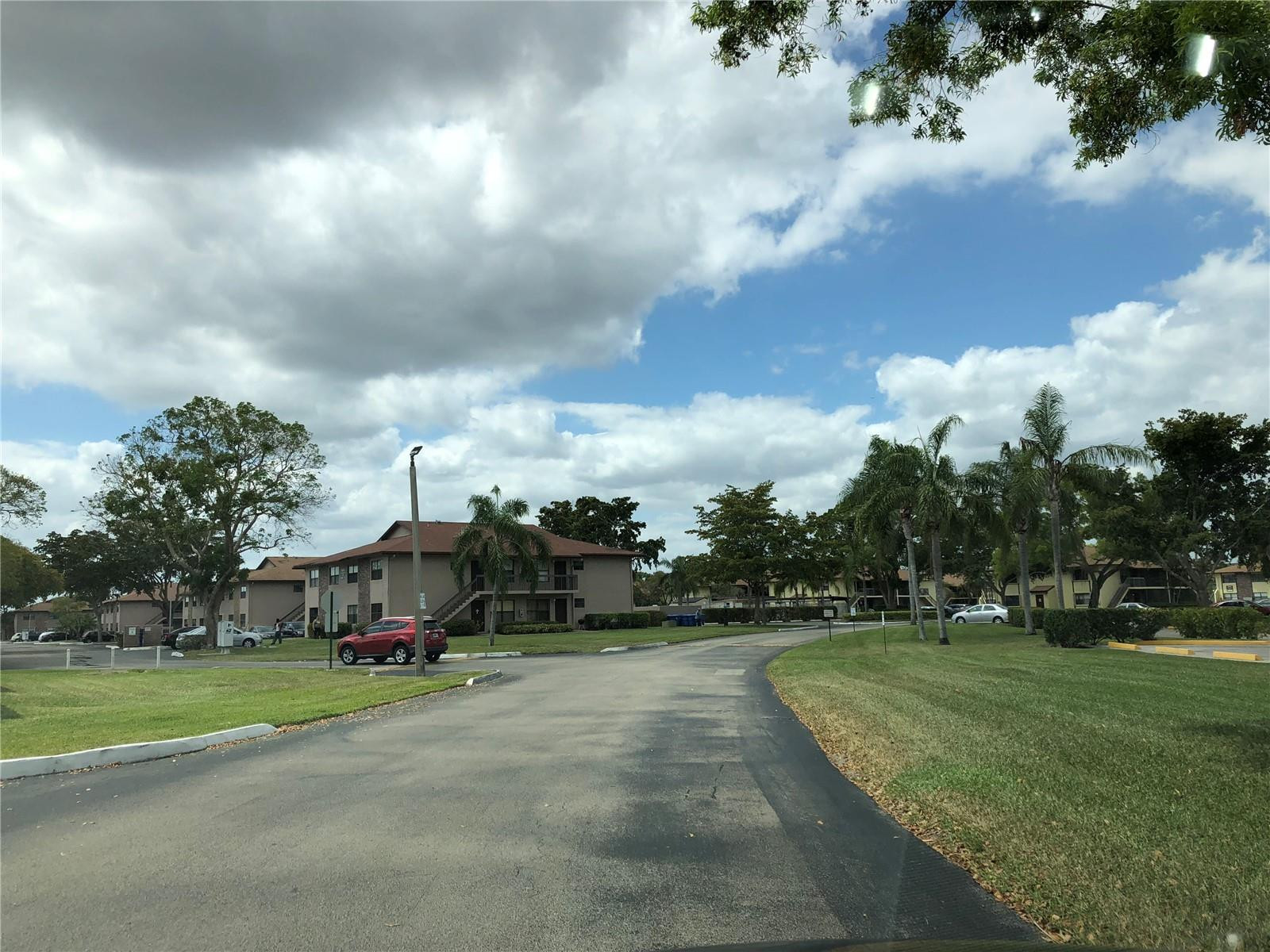 10053 Winding Lake Road, Unit 104 Sunrise, FL 33351 - Photo 41 of 44 a view of street with houses and trees in the background