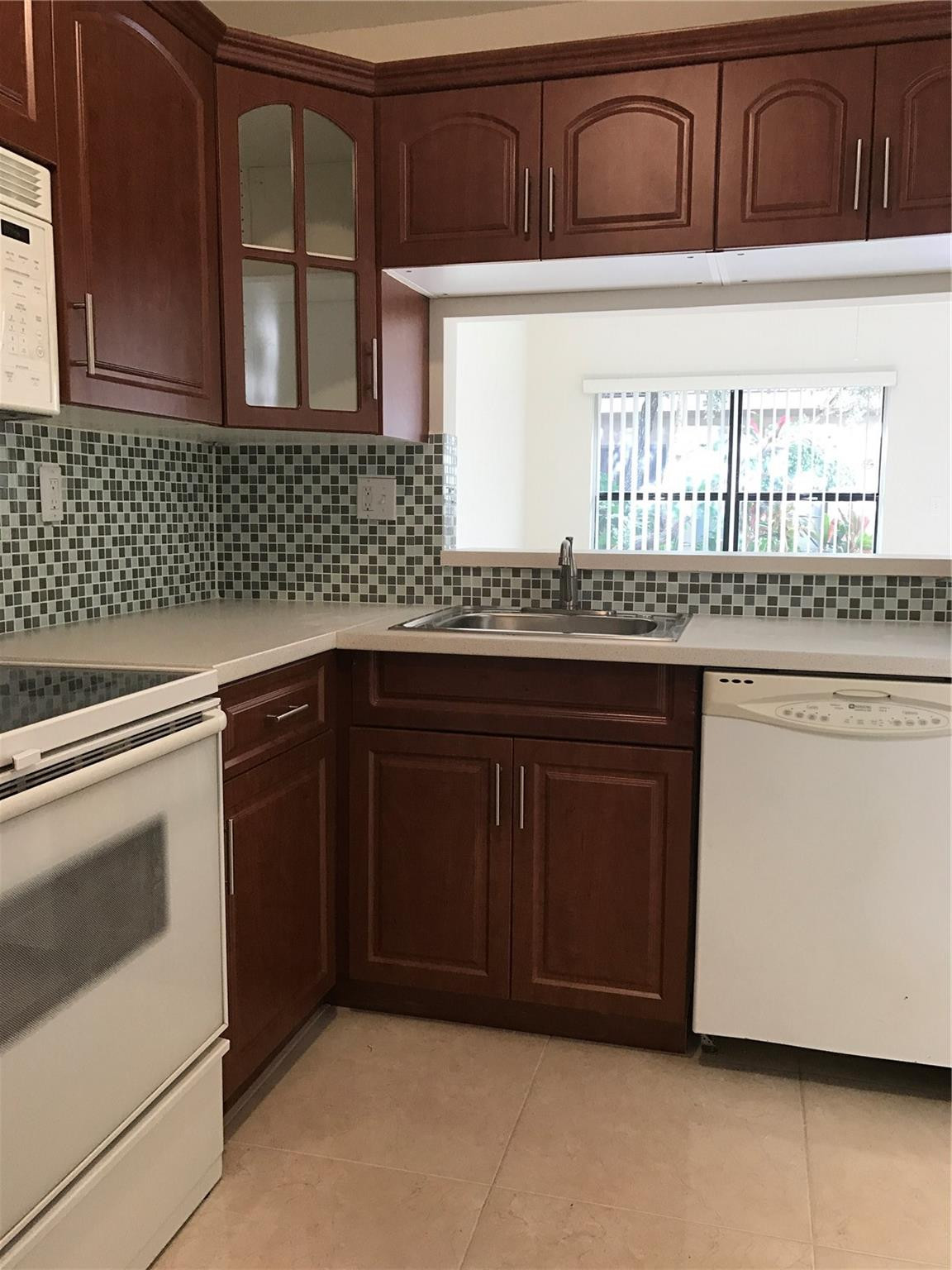 10053 Winding Lake Road, Unit 104 Sunrise, FL 33351 - Photo 5 of 44 a kitchen with granite countertop cabinets stainless steel appliances and a sink