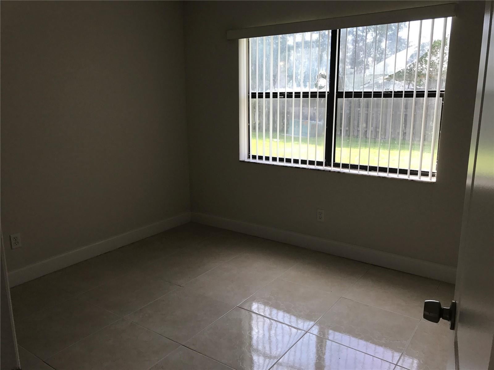 10053 Winding Lake Road, Unit 104 Sunrise, FL 33351 - Photo 10 of 44 a view of an empty room with a window