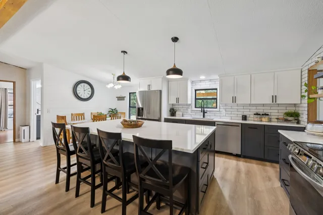 a bed sitting in a bedroom next to a window and a wooden floor