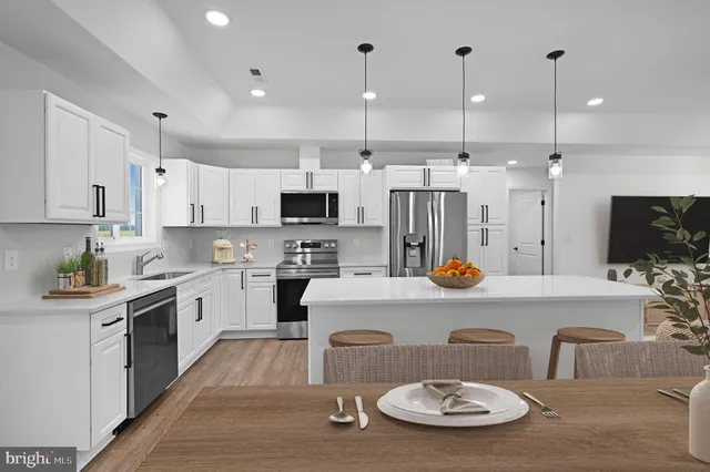 a kitchen with stainless steel appliances granite countertop a sink and white cabinets