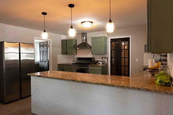 a kitchen with stainless steel appliances granite countertop a refrigerator a sink and a stove