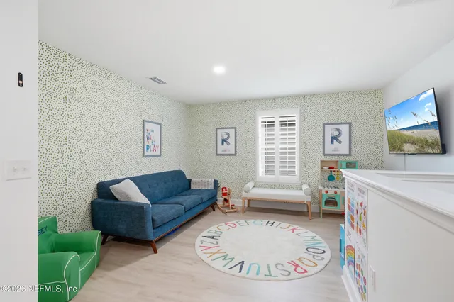 a bedroom with a bed a chandelier and a wooden floor