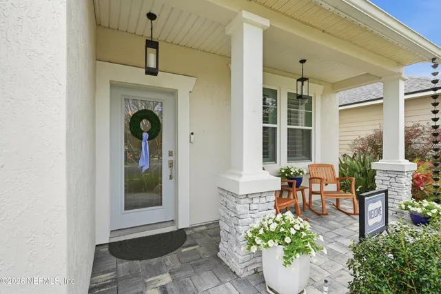 a living room with furniture potted plant and a large window