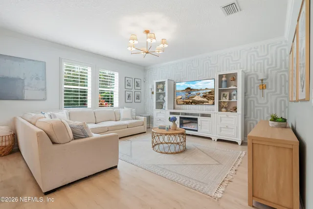 a kitchen with stainless steel appliances granite countertop a refrigerator a stove a sink dishwasher a dining table and chairs with wooden floor