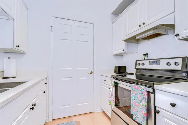 a spacious bedroom with a bed a couch and a chandelier
