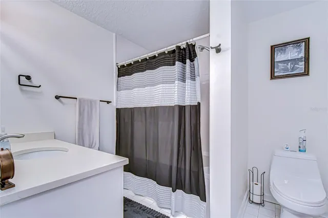 a front view of a building with a garden and trees