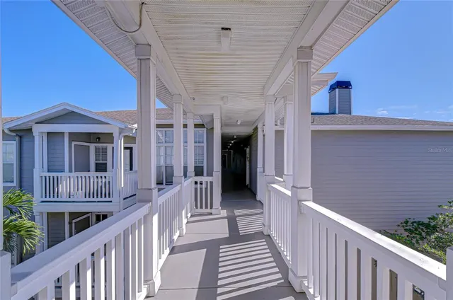 a view of a patio with couches table and chairs under an umbrella