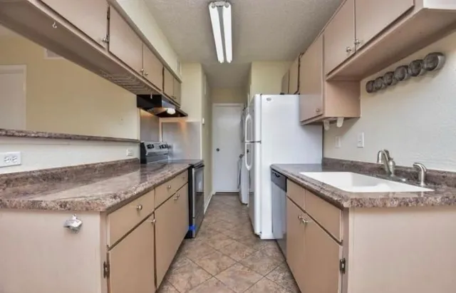 a kitchen with stainless steel appliances granite countertop a sink stove and cabinets