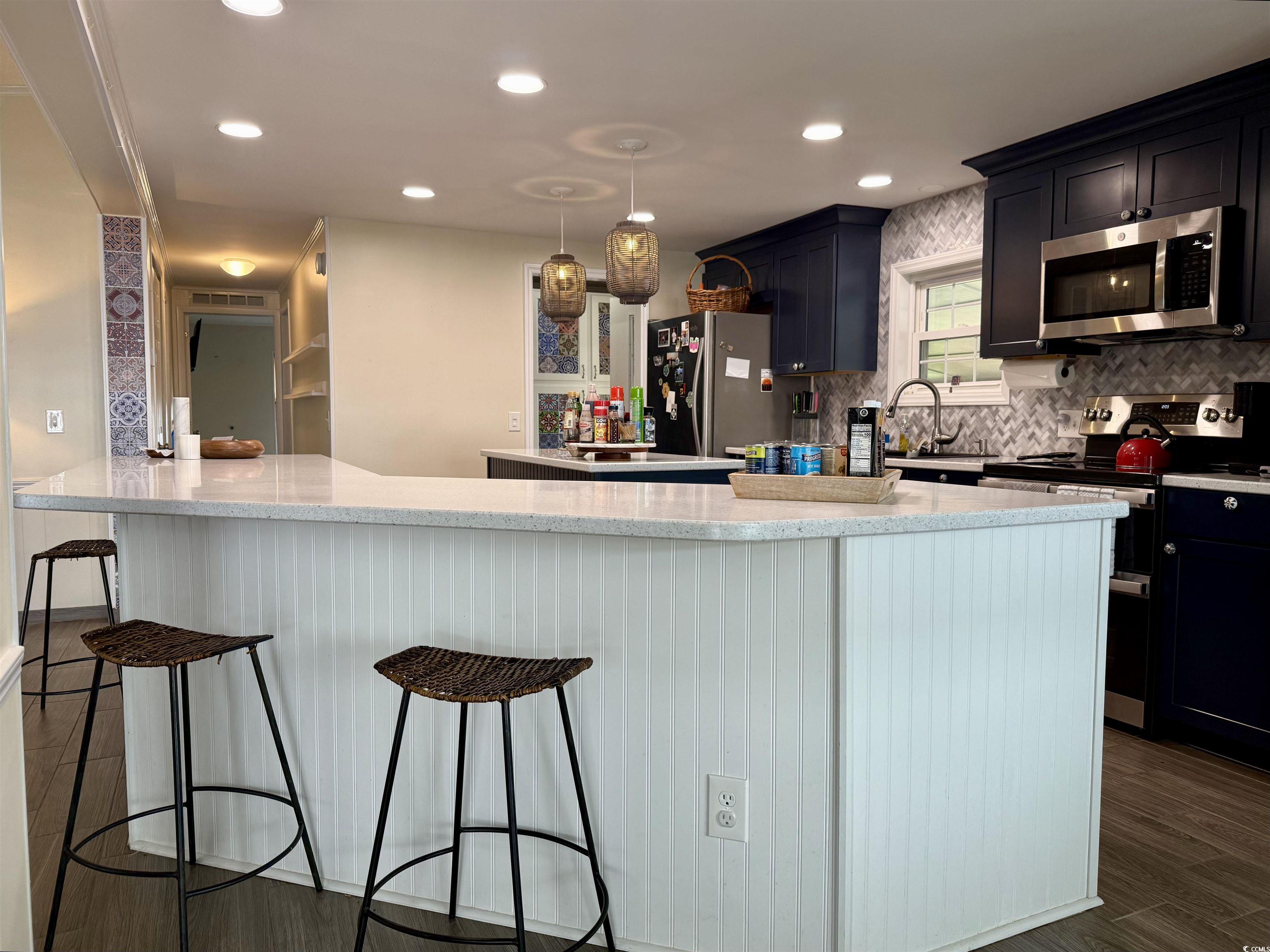 527 Sandpebble Surfside Beach, SC 29575 - Photo 7 of 31 Kitchen with a kitchen bar, decorative backsplash,
