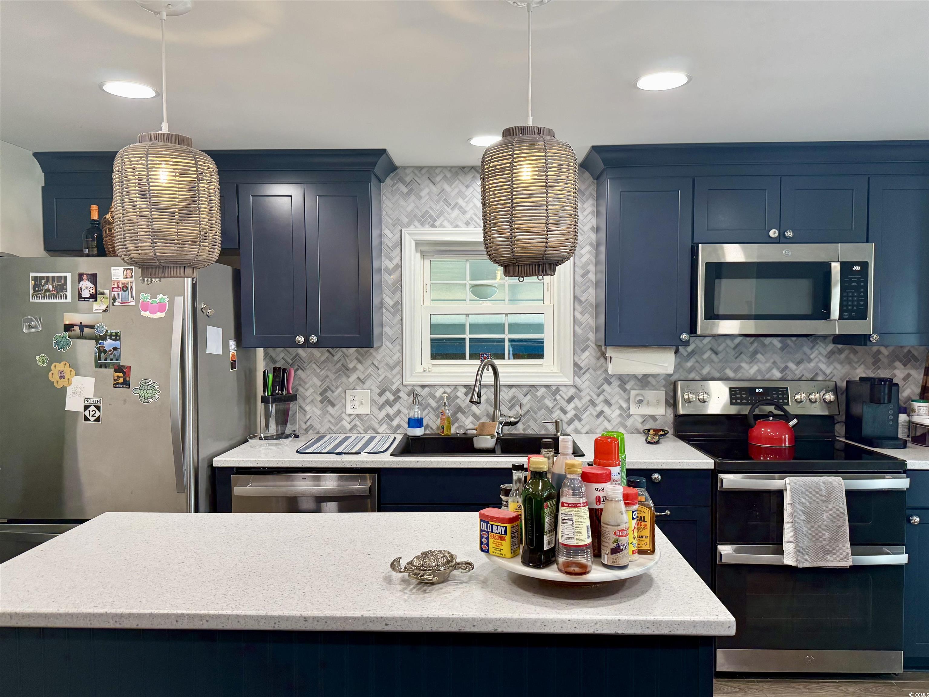 527 Sandpebble Surfside Beach, SC 29575 - Photo 9 of 31 Kitchen featuring blue cabinets, hanging light fix