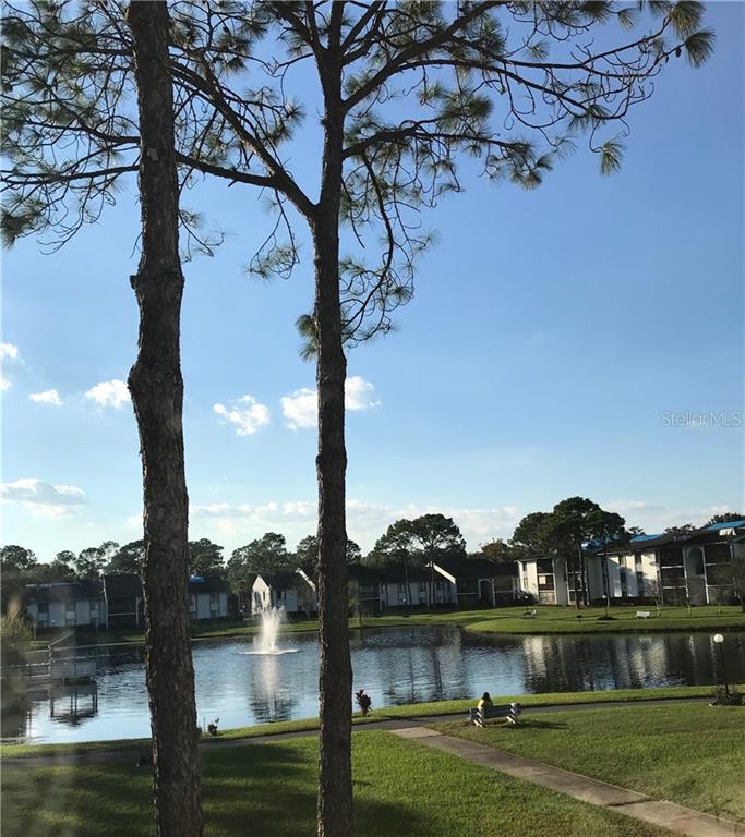 8203 Sun Spring Circle, Unit C1 Orlando, FL 32825 - Photo 1 of 1 a view of a lake with a yard and large trees