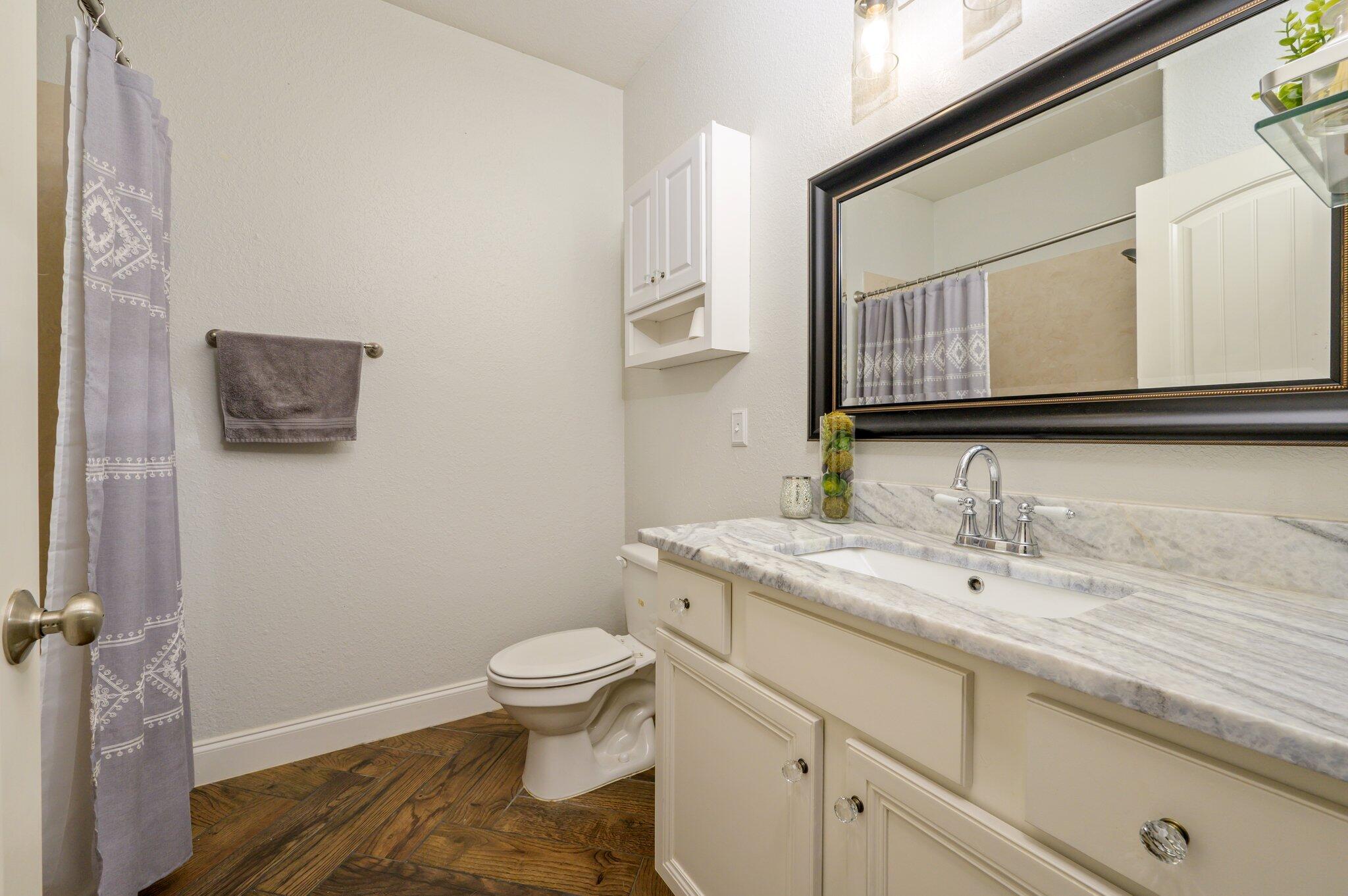 4545 Hermosa Road Crestview, FL 32539 - Photo 24 of 36 a bathroom with a granite countertop toilet sink and mirror
