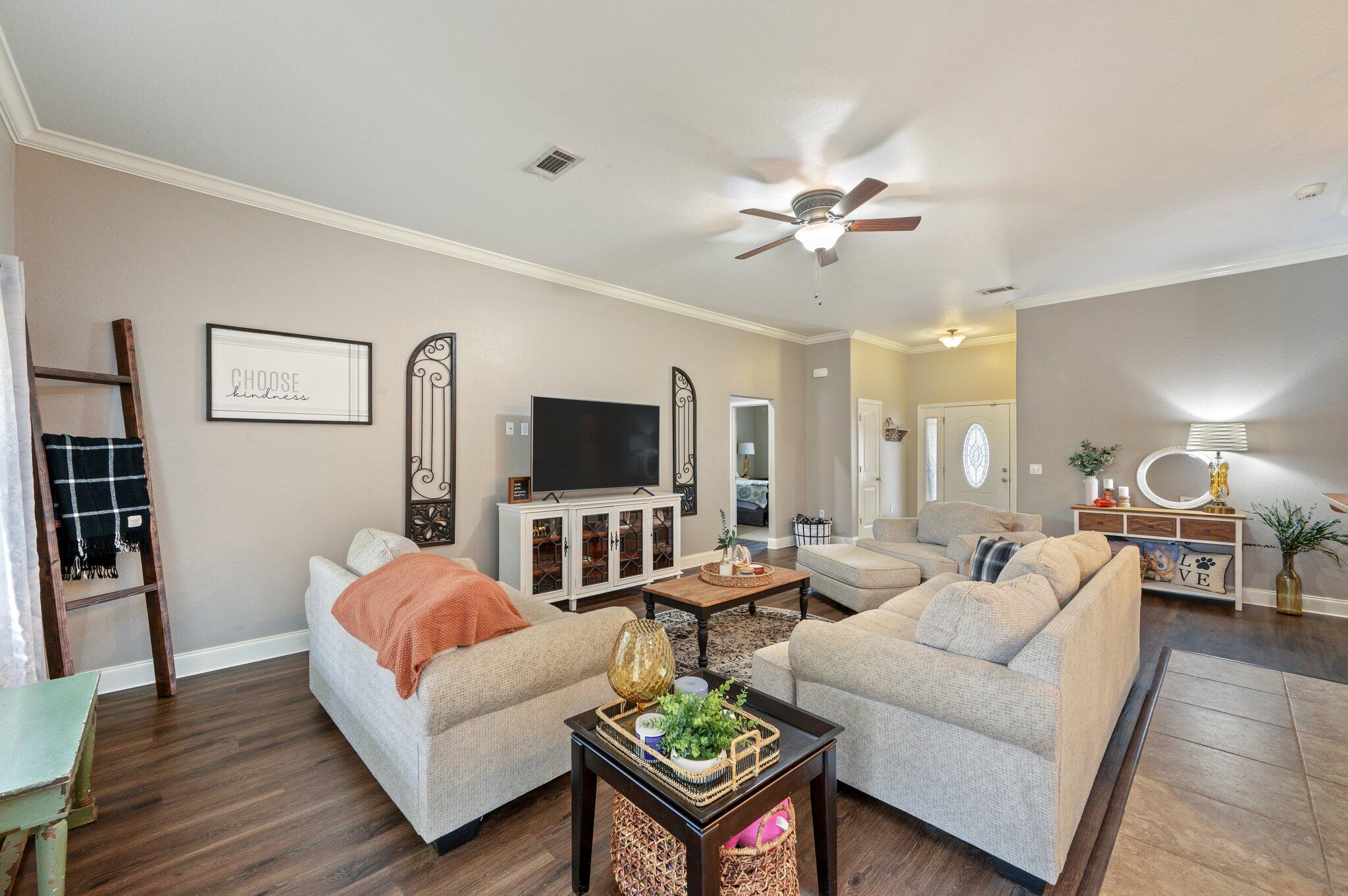 4545 Hermosa Road Crestview, FL 32539 - Photo 7 of 36 a living room with furniture a flat screen tv and a fireplace