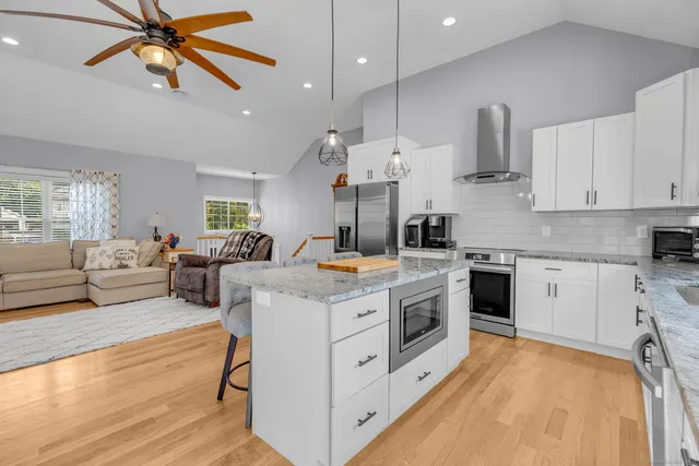 a kitchen with stainless steel appliances granite countertop a stove and a white cabinets