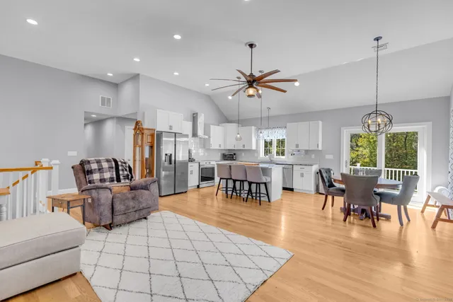 a living room with furniture and kitchen view with wooden floor