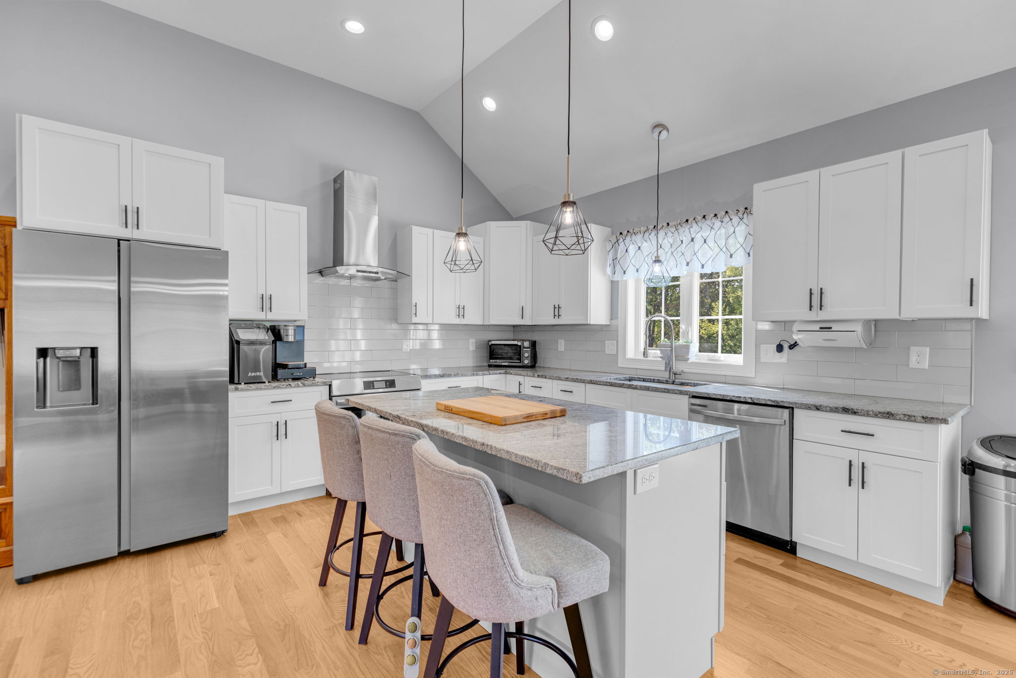 1209 Woodtick Road Wolcott, CT 06716 - Photo 6 of 40 a kitchen with stainless steel appliances granite countertop a stove a sink a microwave a refrigerator and white cabinets with wooden floor