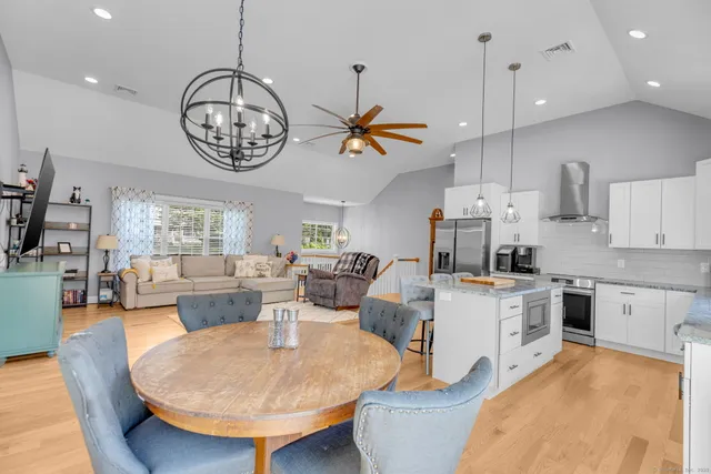 a living room with kitchen island furniture and a chandelier