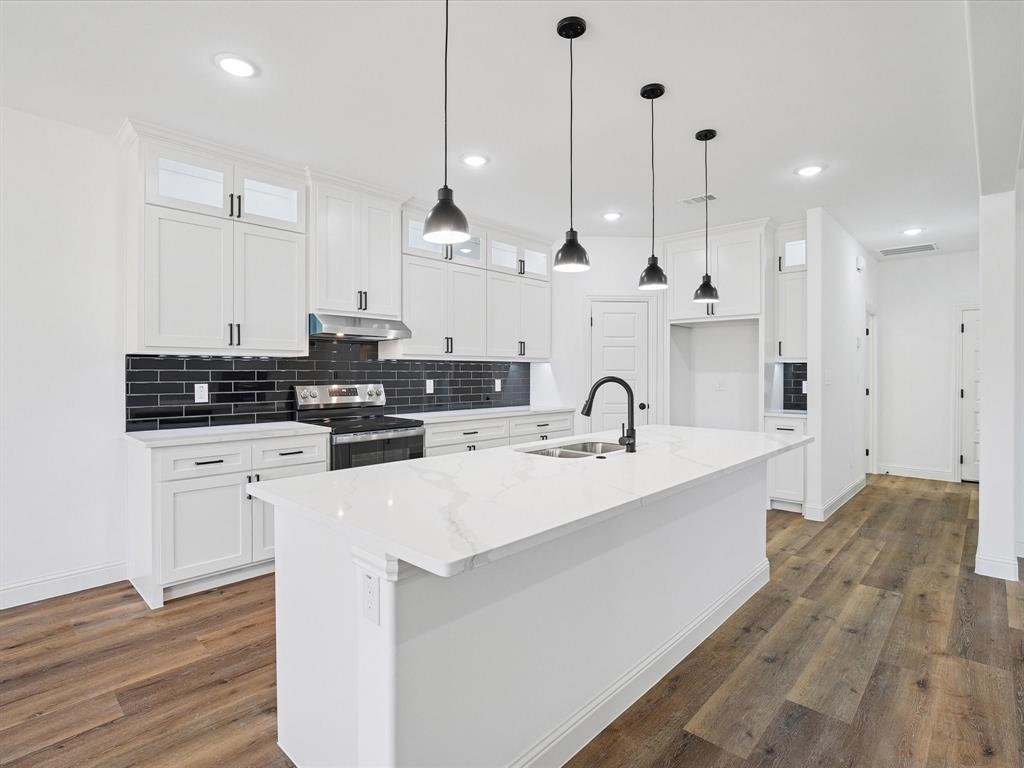 448 Rs County Road Alba, TX 75410 - Photo 22 of 34 a kitchen with stainless steel appliances granite countertop a sink a stove a refrigerator and white cabinets with wooden floor