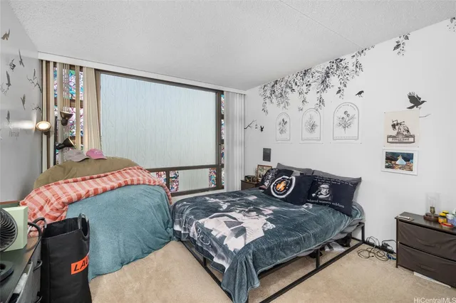 a bedroom with a bed and dresser next to a window