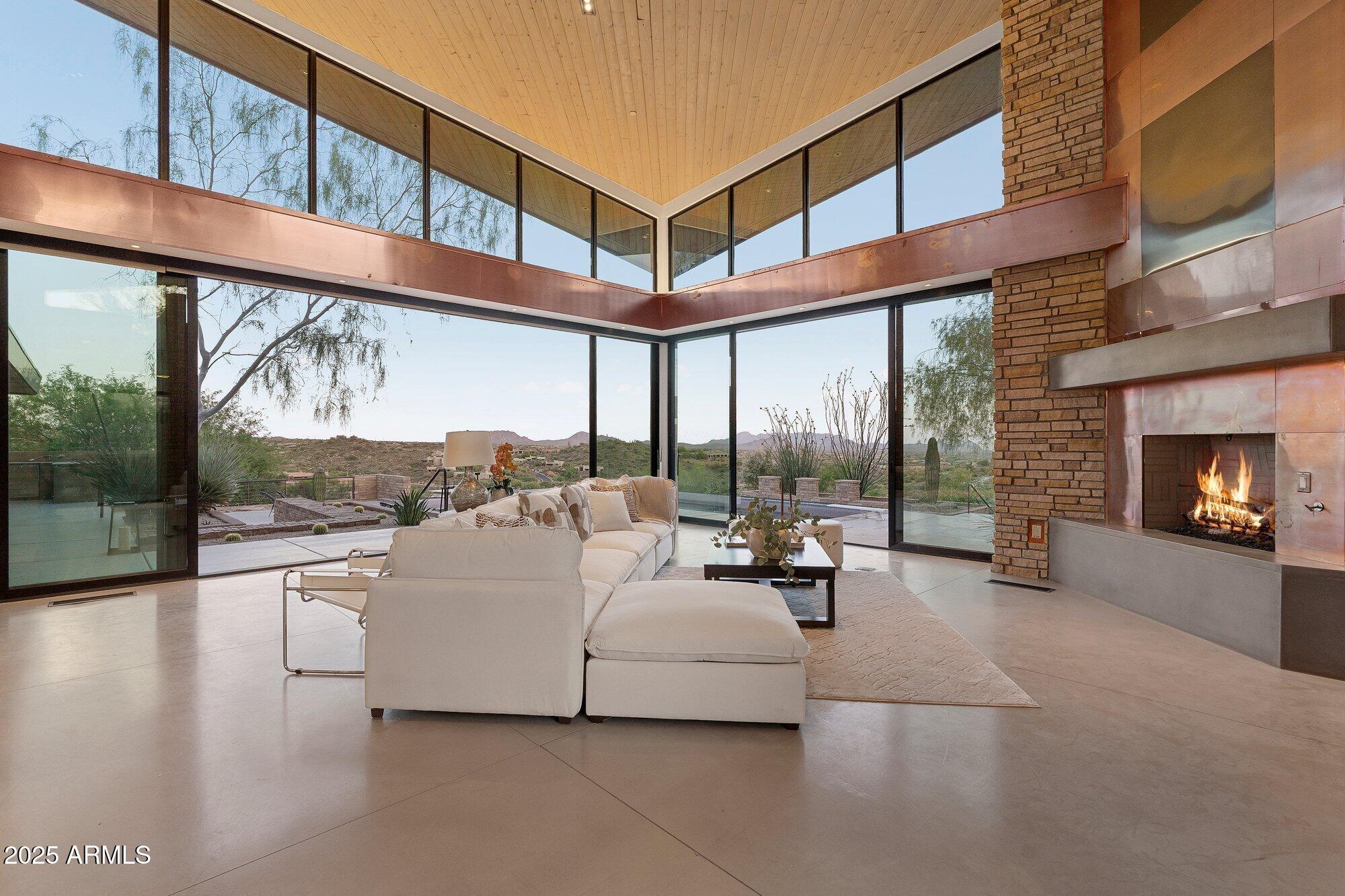 9626 East Aw Tillinghast Road Scottsdale, AZ 85262 - Photo 5 of 28 a living room with furniture a fireplace and floor to ceiling windows