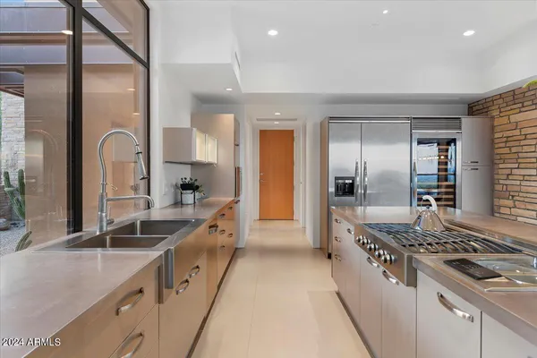 a large kitchen with stainless steel appliances granite countertop a lot of counter space and a sink