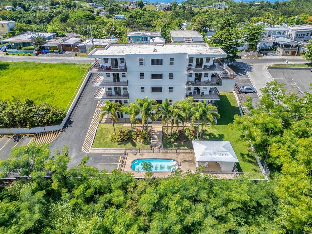 413 Camino Carretas, Unit A7 Rincon, Rincón 00677 - Photo 18 of 23 a view of a large pool with lawn chairs and plants