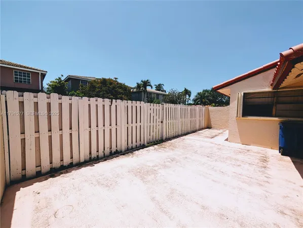 a view of a backyard with wooden fence