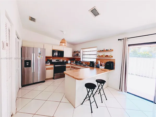 a kitchen with stainless steel appliances a refrigerator a stove a sink dishwasher and a refrigerator with wooden floor